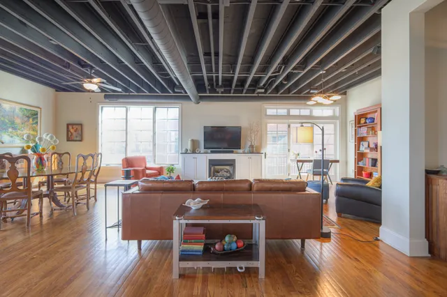 a living room with furniture a wooden floor and a fireplace