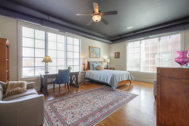 a bedroom with a bed a couch and a window