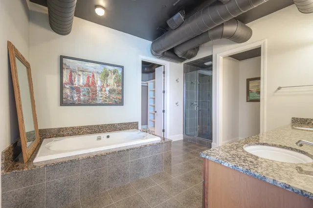 a bathroom with a granite countertop tub sink and mirror