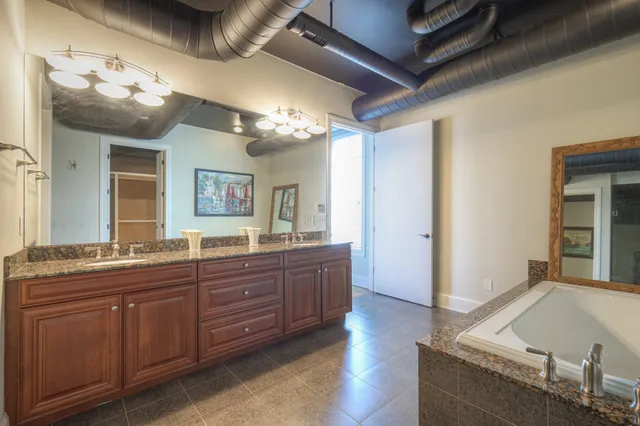 a spacious bathroom with a granite countertop sink and a mirror