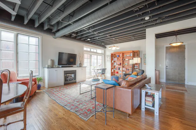 a living room with furniture flat screen tv and wooden floor
