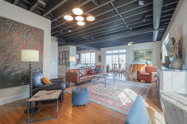 a living room with furniture a fireplace and a chandelier