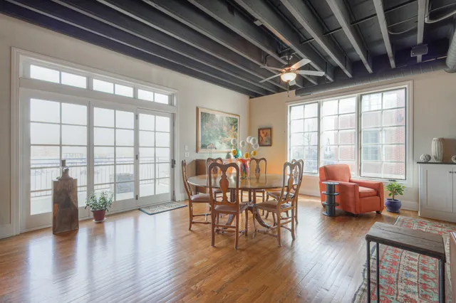 a dining room with wooden floor furniture and a floor to ceiling window