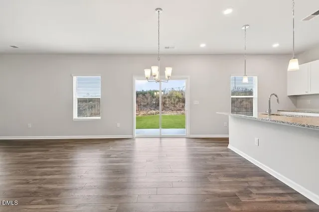 a view of empty room with wooden floor and window