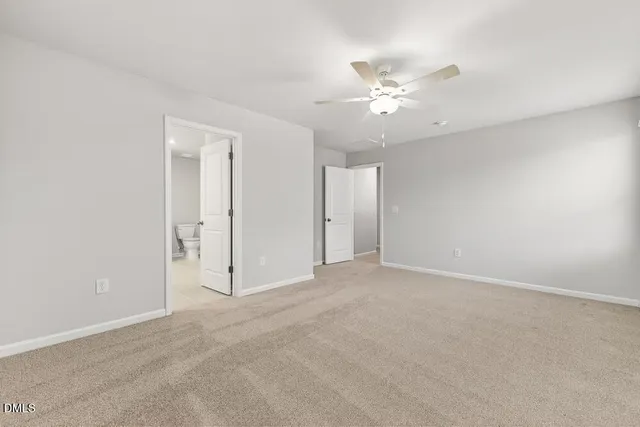 an empty room with fan and entryway