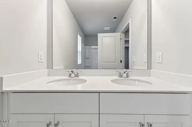 a bathroom with a double vanity sink and a mirror