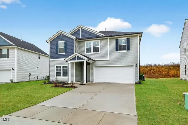 a front view of a house with a yard and garage