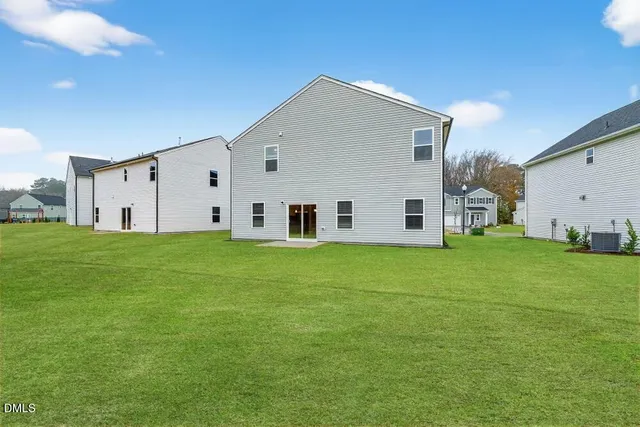 a view of a white house with a big yard