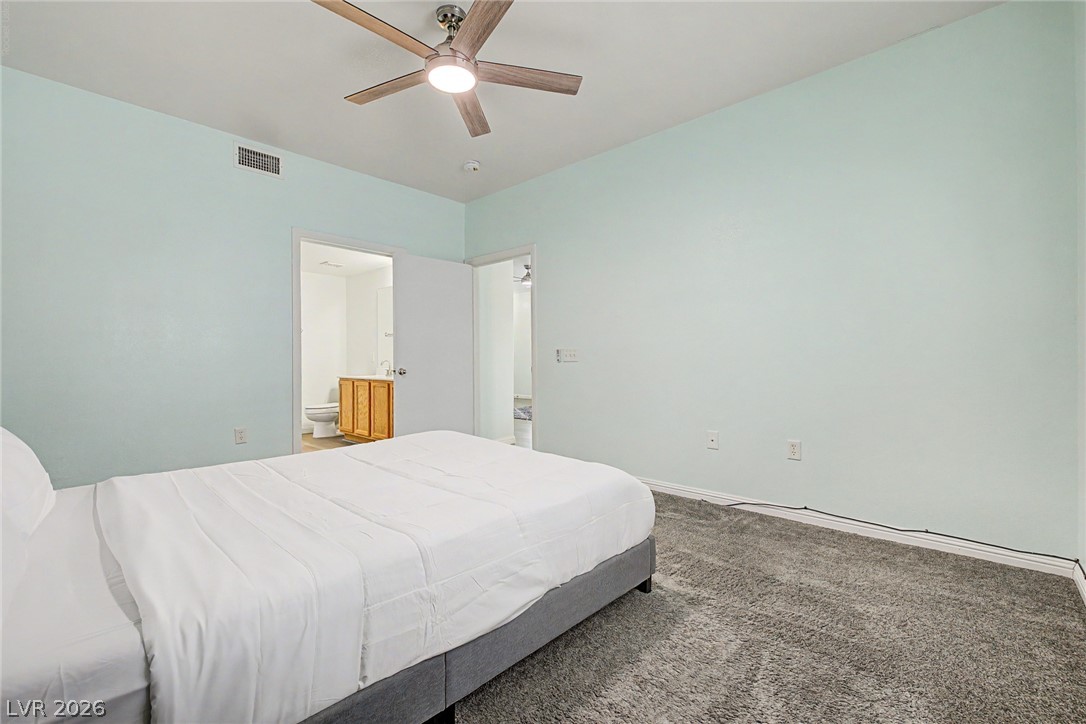 2153 Quarry Ridge Street, Unit 103 Las Vegas, NV 89117 - Photo 20 of 42 Comfortable carpeting and a ceiling fan create a serene atmosphere in this inviting bedroom.