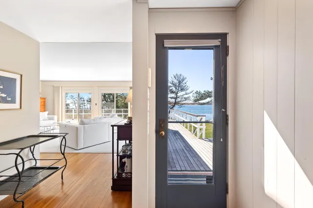 a view of a hallway with wooden floor and dining room view