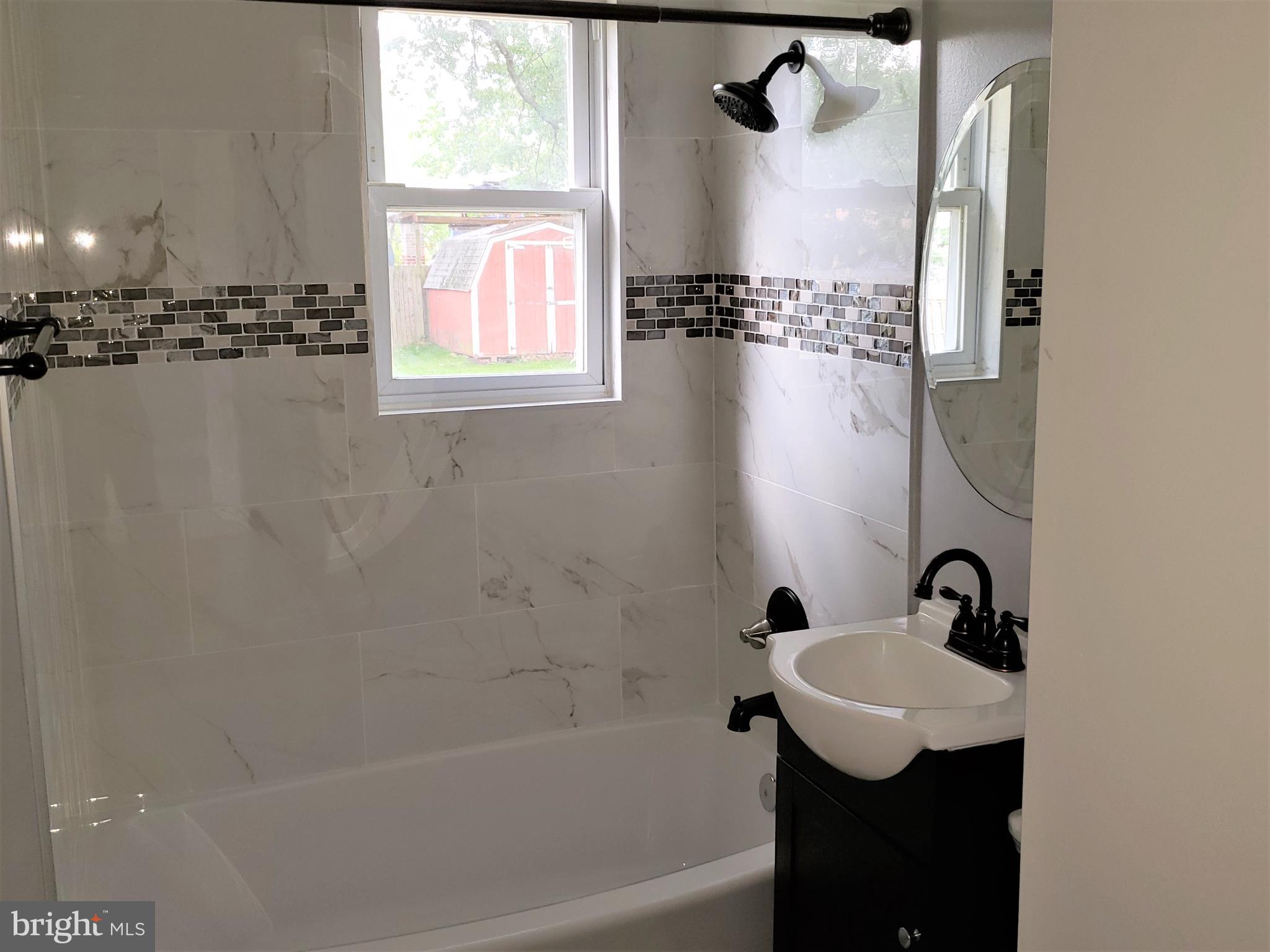 4709 68th Avenue Hyattsville, MD 20784 - Photo 14 of 30 a bathroom with a granite countertop sink a window and a mirror