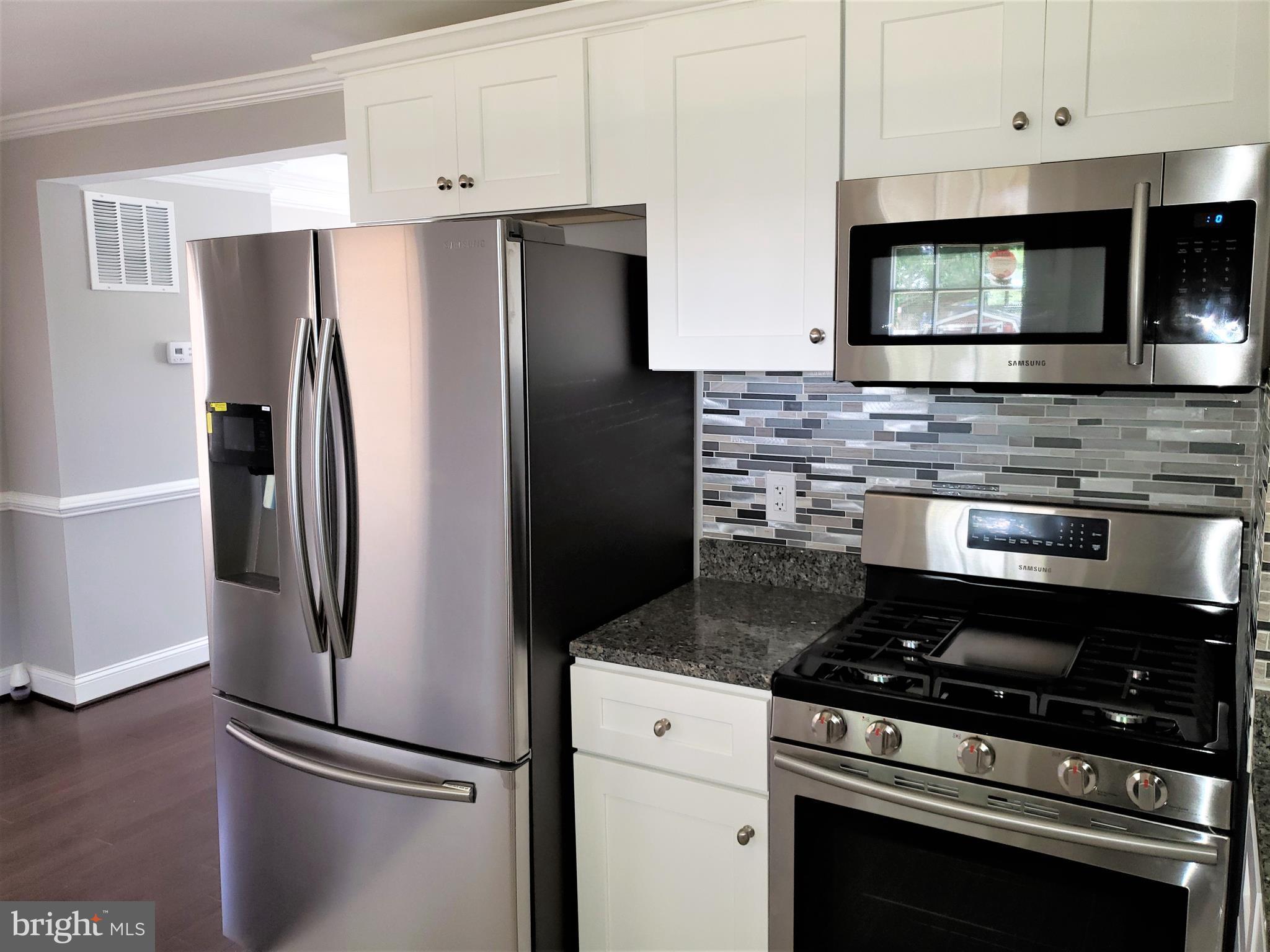 4709 68th Avenue Hyattsville, MD 20784 - Photo 8 of 30 a kitchen with stainless steel appliances a refrigerator stove and microwave