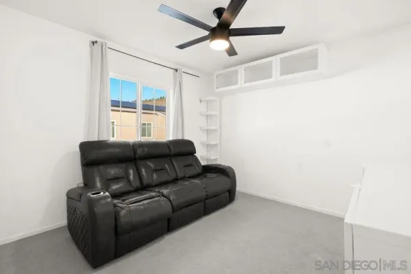 a living room with furniture and a ceiling fan