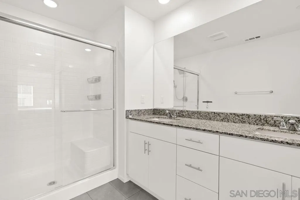 347 Sweet Place Fallbrook, CA 92028 - Photo 7 of 33 a bathroom with a granite countertop sink a mirror and shower