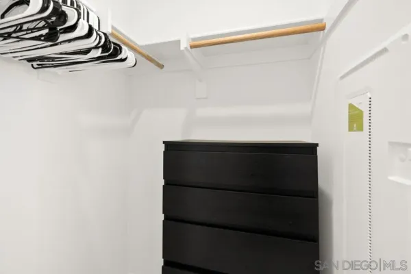 a view of walk in closet with clothes