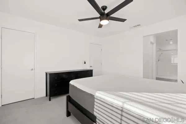 a room with a bed and a ceiling fan