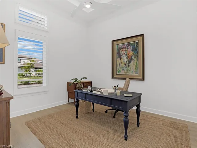 a view of a workspace with furniture and a window