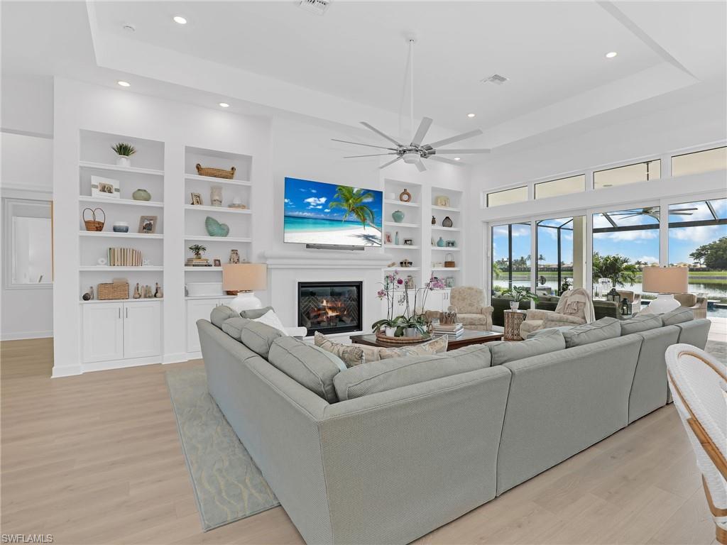 15432 Turin Drive Naples, FL 34114 - Photo 2 of 45 a living room with furniture a fireplace and a flat screen tv