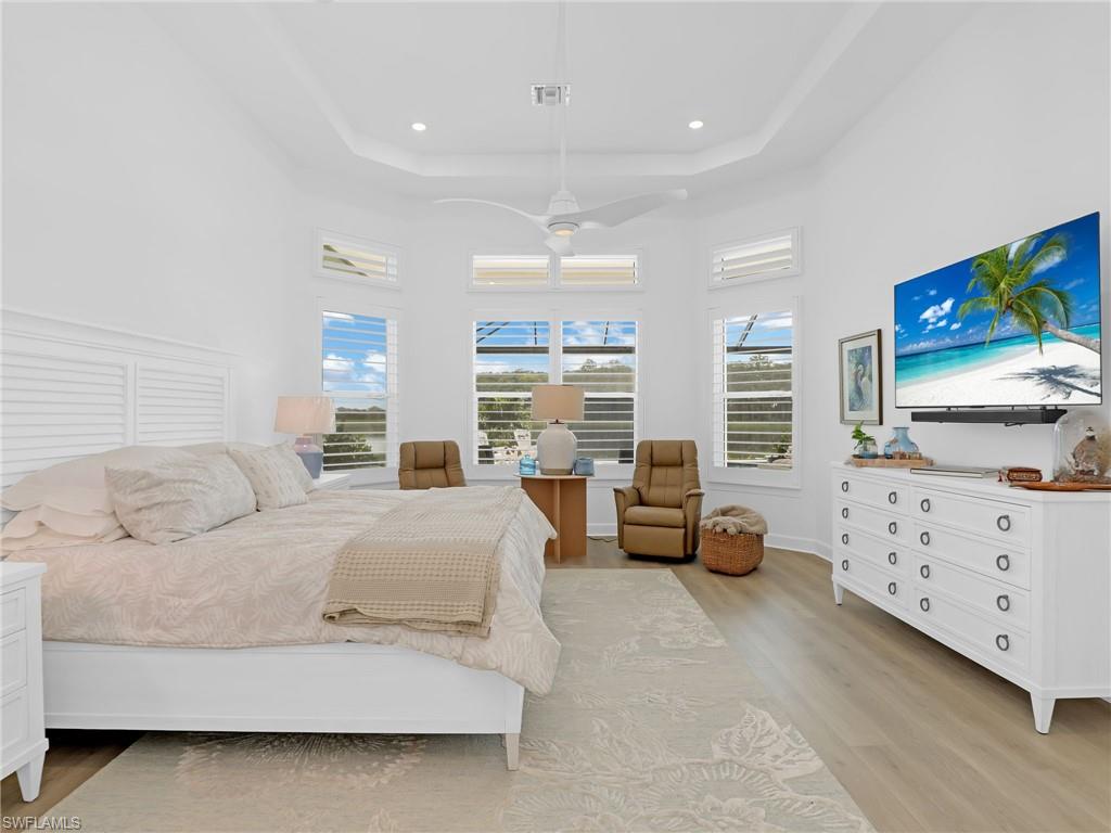 15432 Turin Drive Naples, FL 34114 - Photo 22 of 45 a spacious bedroom with a bed a couch and large window