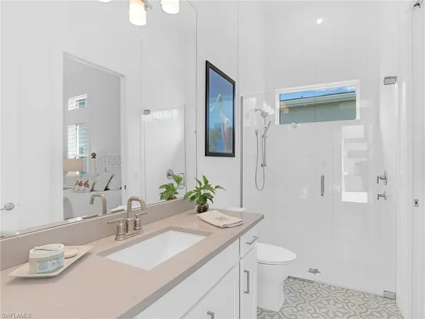 a bathroom with a granite countertop sink a toilet and a mirror