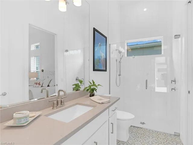 a bathroom with a granite countertop sink a toilet and a mirror