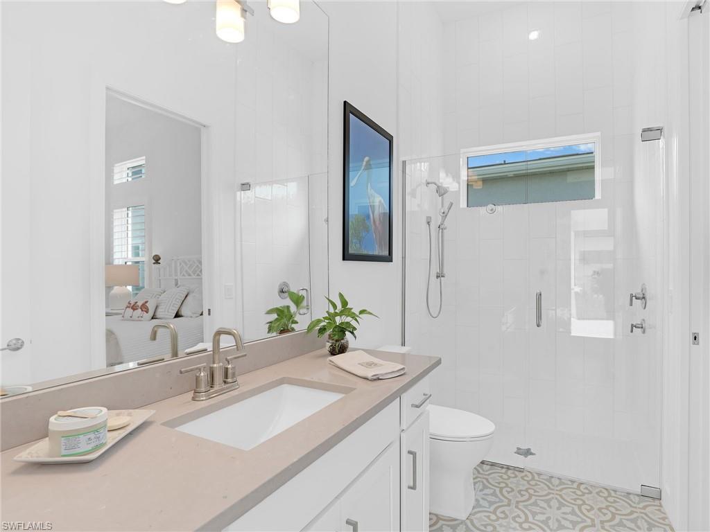 15432 Turin Drive Naples, FL 34114 - Photo 28 of 45 a bathroom with a granite countertop sink a toilet and a mirror