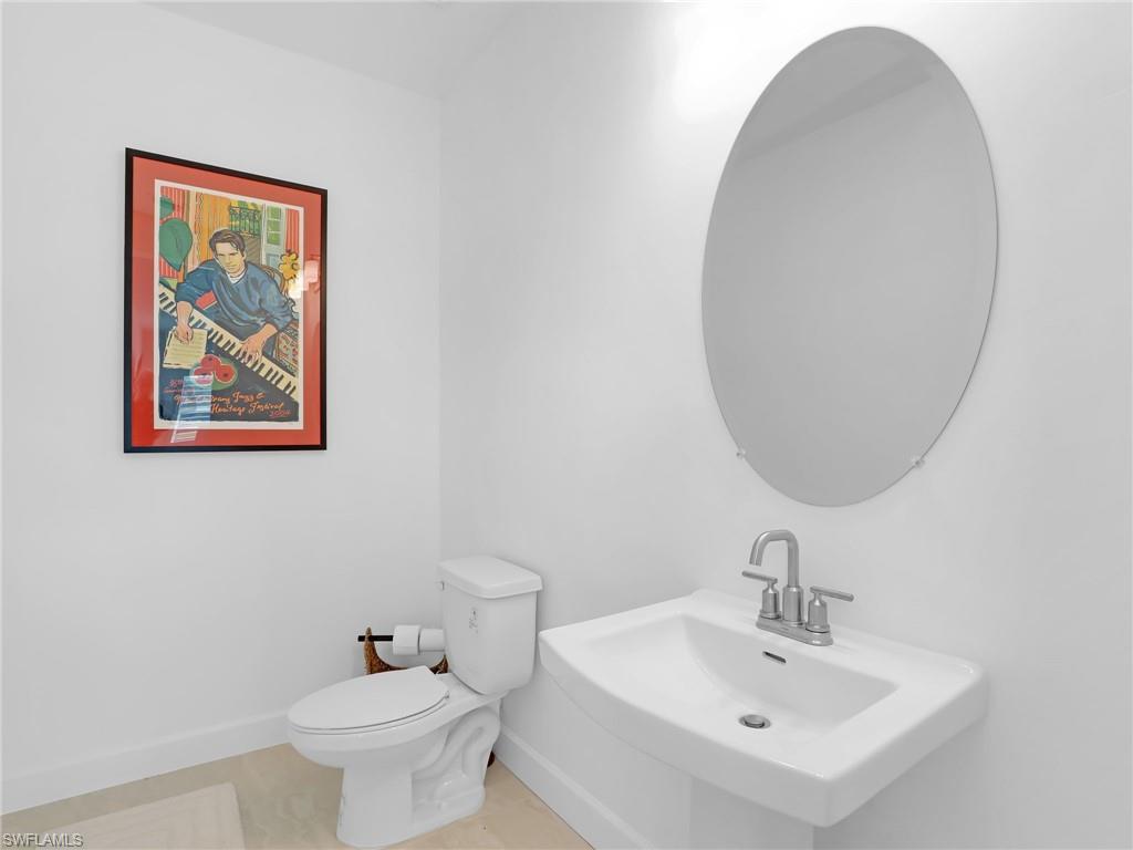 15432 Turin Drive Naples, FL 34114 - Photo 30 of 45 a bathroom with a toilet a sink and mirror