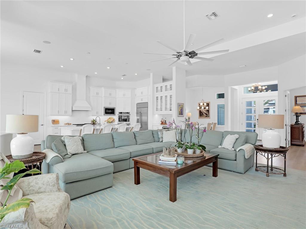 15432 Turin Drive Naples, FL 34114 - Photo 3 of 45 a living room with furniture a rug and a chandelier
