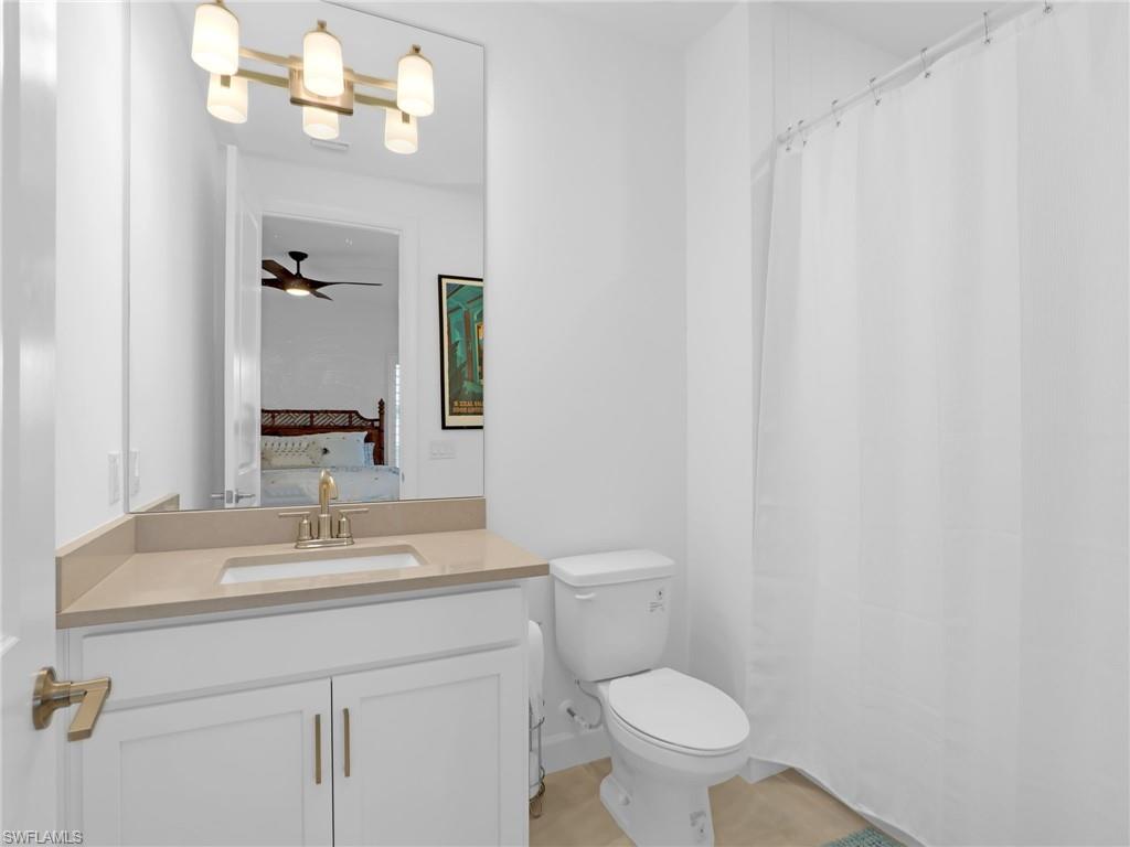 15432 Turin Drive Naples, FL 34114 - Photo 33 of 45 a bathroom with a sink a toilet and a mirror