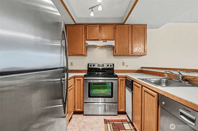 a kitchen with stainless steel appliances granite countertop a stove a sink and a microwave