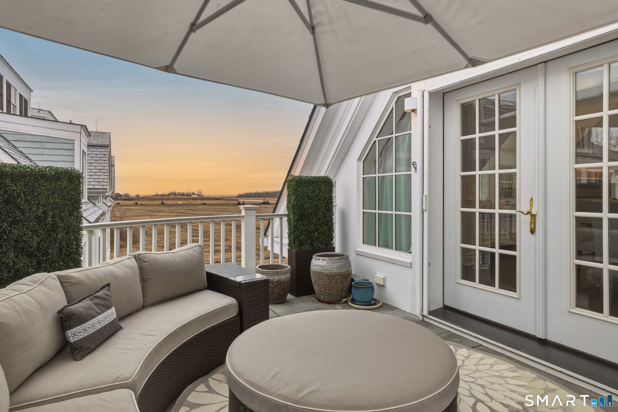 66 High Street, Unit 38 Guilford, CT 06437 - Photo 16 of 40 a balcony with furniture and wooden floor