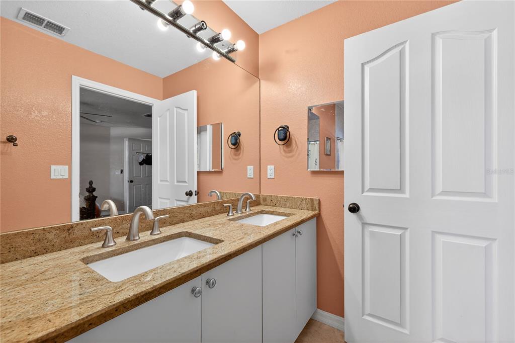 1429 Laredo Avenue Spring Hill, FL 34608 - Photo 17 of 28 a bathroom with a granite countertop sink and a mirror