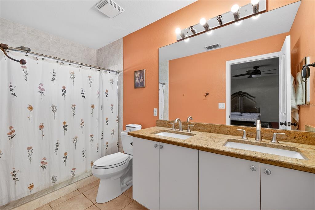 1429 Laredo Avenue Spring Hill, FL 34608 - Photo 18 of 28 a bathroom with a granite countertop sink a toilet and a mirror