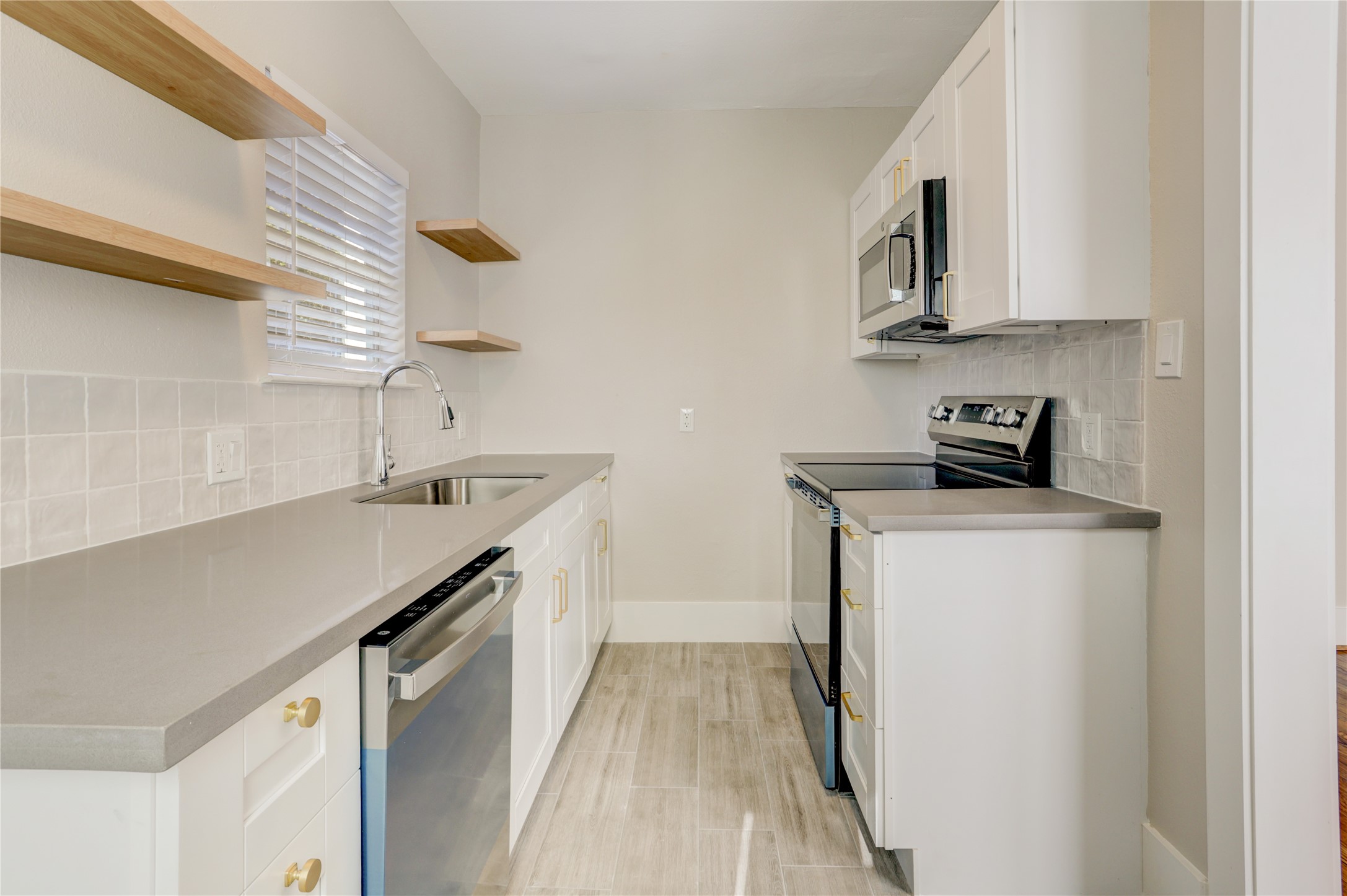 4314 Bell Street, Unit 1 Houston, TX 77023 - Photo 14 of 17 a kitchen with stainless steel appliances a sink a stove and a refrigerator