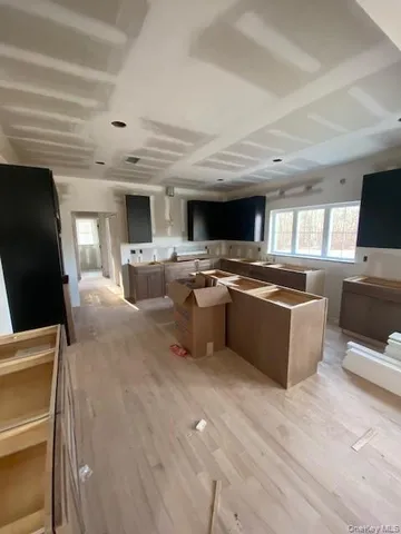 a large white kitchen with stainless steel appliances granite countertop a stove and a sink