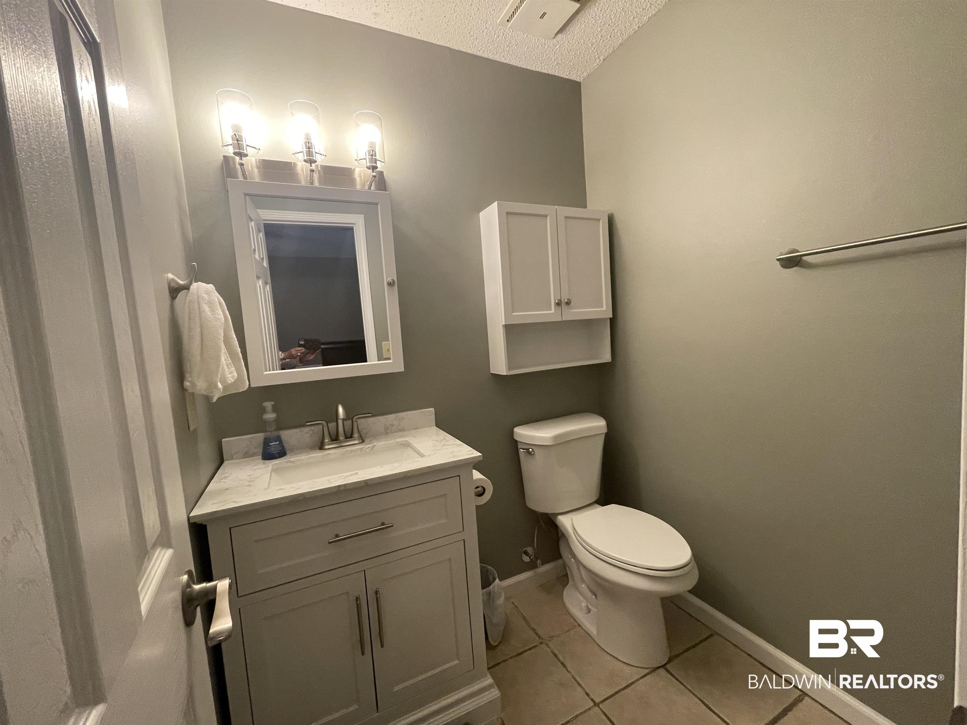 2274 Foshee Road Brewton, AL 36426 - Photo 13 of 23 Half bathroom featuring vanity, tile patterned flooring, and a textured ceiling
