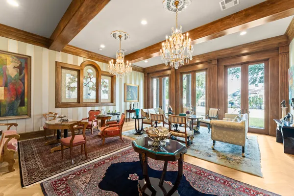 a living room with furniture a large window and a chandelier