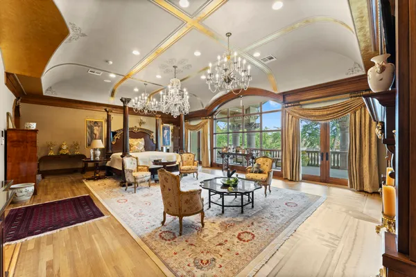 a living room with lots of furniture wooden floor and chandelier