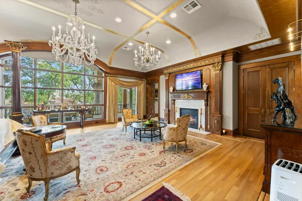 a living room with fireplace furniture and a chandelier
