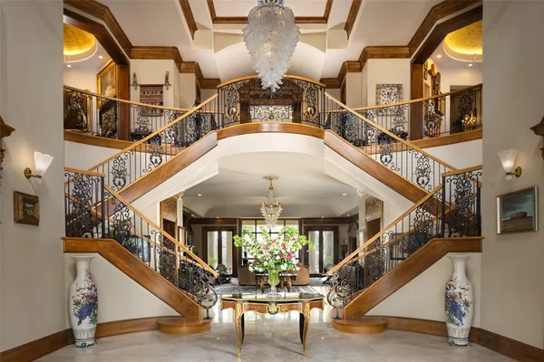a view of staircase with large windows and a chandelier