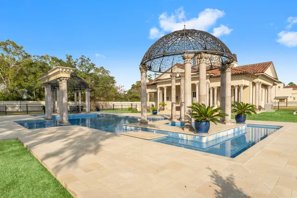 a kitchen with granite countertop a sink a stove top oven and cabinetry