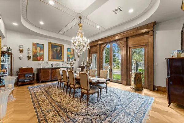 a view of a dining room with furniture a chandelier and wooden floor