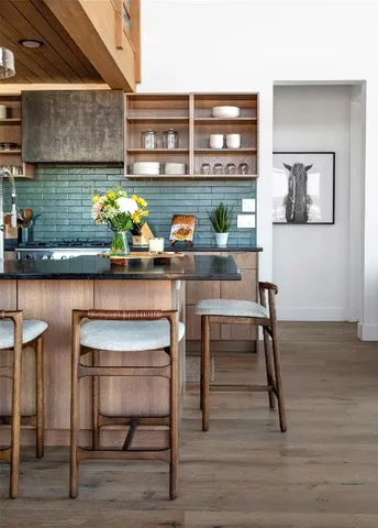 a kitchen with stainless steel appliances granite countertop a sink and a wooden floor