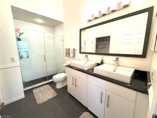 a bathroom with a double vanity sink toilet and shower