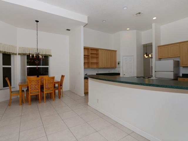 12557 154th Road North Jupiter, FL 33478 - Photo 13 of 38 a kitchen with stainless steel appliances kitchen island granite countertop a table and chairs in it
