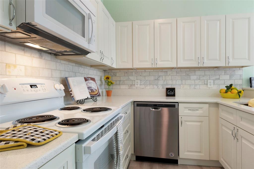 1050 Starkey Road, Unit 208 Largo, FL 33771 - Photo 13 of 30 a kitchen with a sink a stove and cabinets