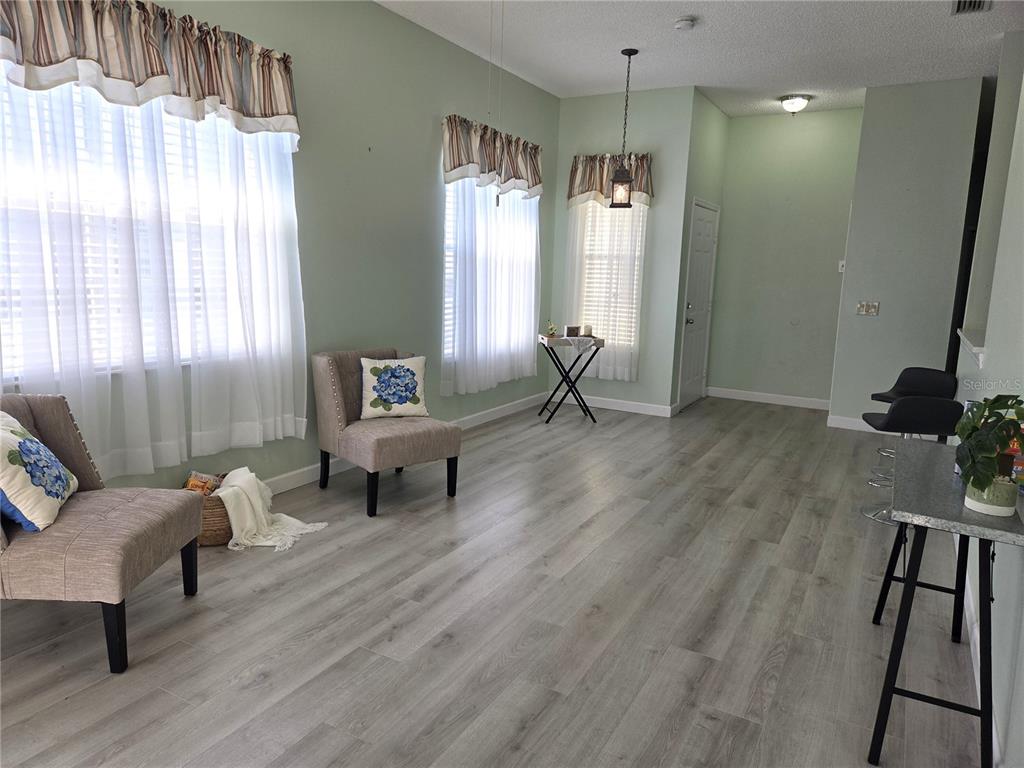 1050 Starkey Road, Unit 208 Largo, FL 33771 - Photo 8 of 30 a living room with furniture and a chandelier