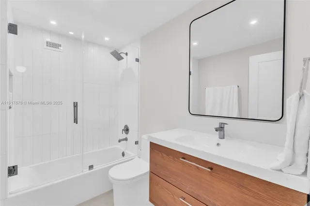 a bathroom with a bathtub shower sink and toilet