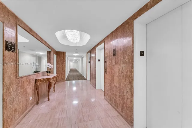 a view of a hallway with wooden floor windows and chandelier