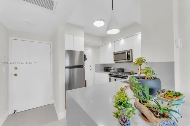 a kitchen with stainless steel appliances granite countertop a refrigerator a stove a microwave oven with a sink